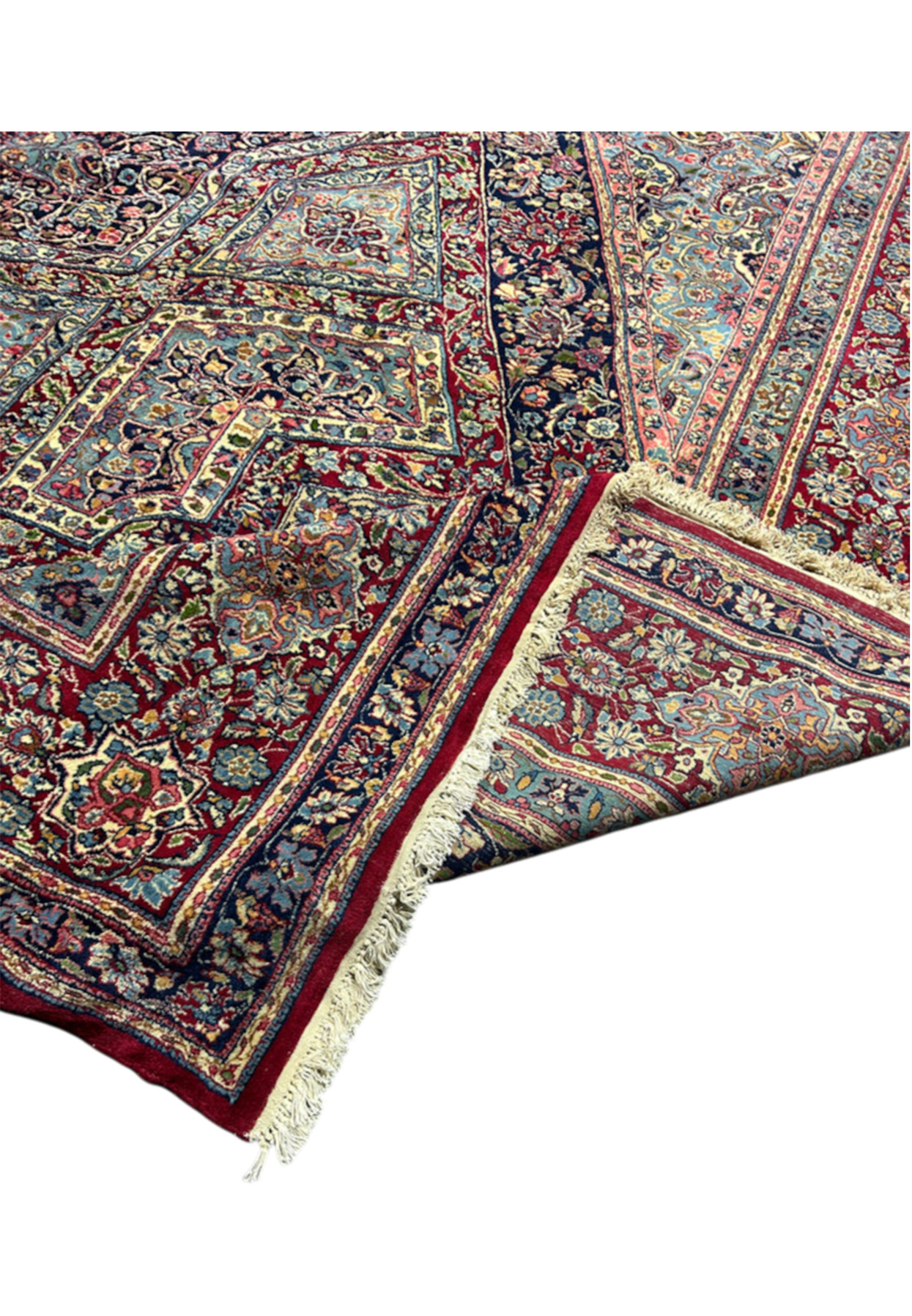 Folded corner of the 18x18 antique rug showing the red reverse and original fringe