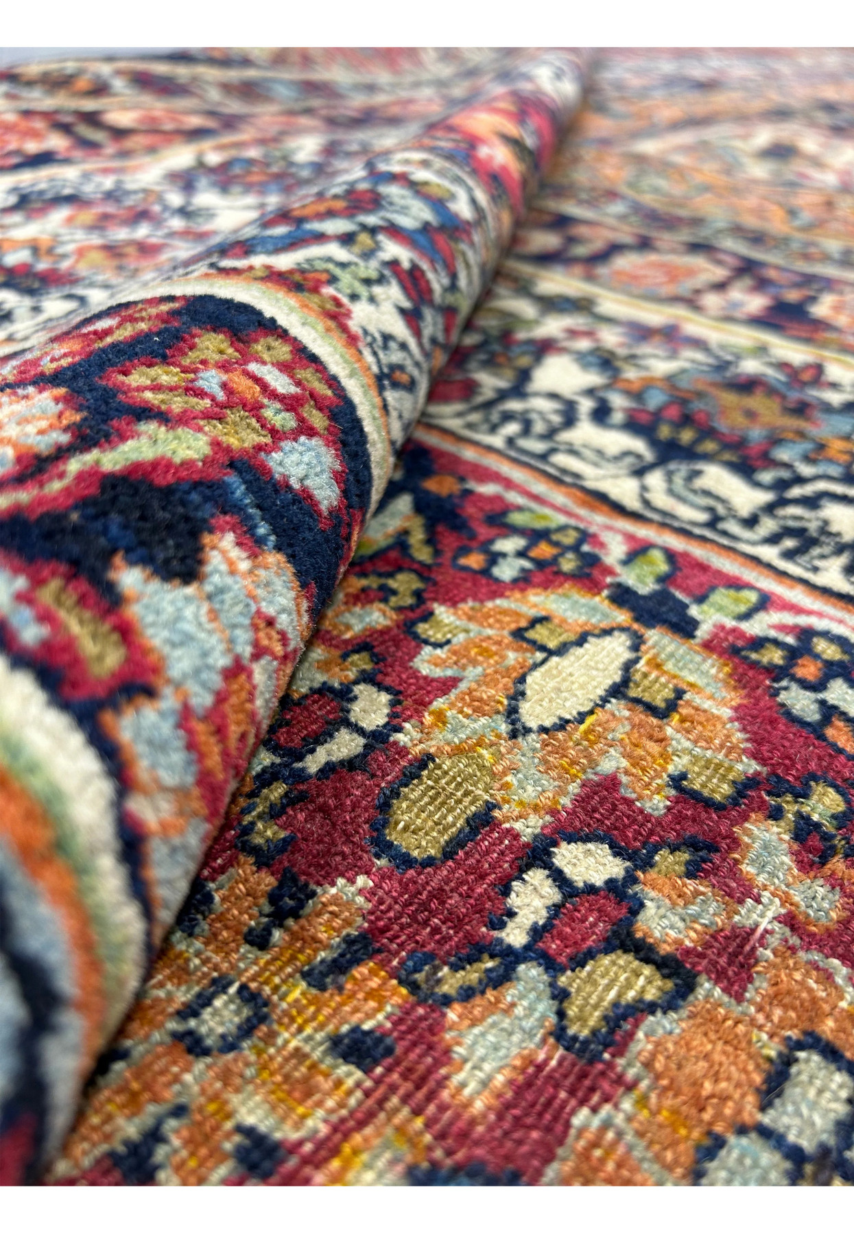 13x18 Kermanshah rug rolled back to reveal pile depth and unworn red border wool