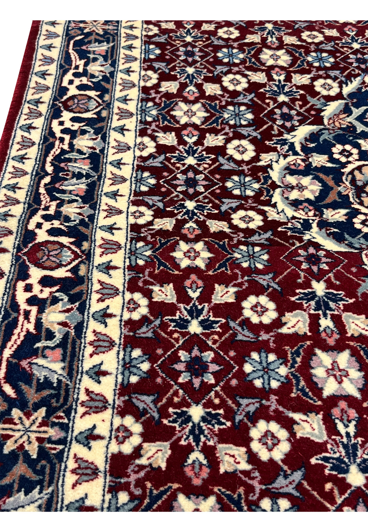 Side view of a hand knotted Persian Tabriz rug showing clean edges, even pile height, structured borders, and high quality traditional weaving