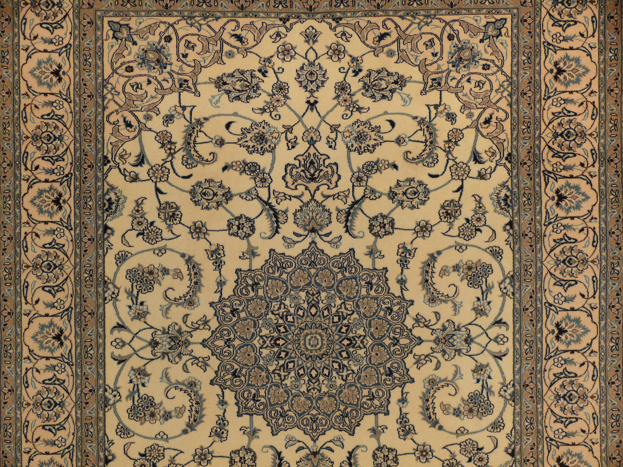 Detail of the medallion core and surrounding arabesque scrollwork in camel and slate blue