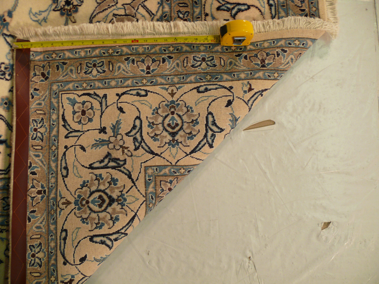 Folded corner showing front and reverse together, fine wool and silk pile on a pale ground
