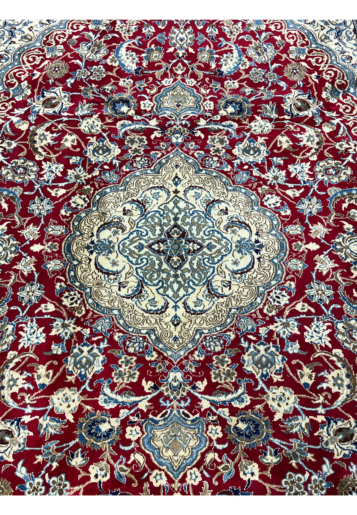 Central medallion of red Persian Nain rug with ivory ground, navy arabesques, and refined silk accents