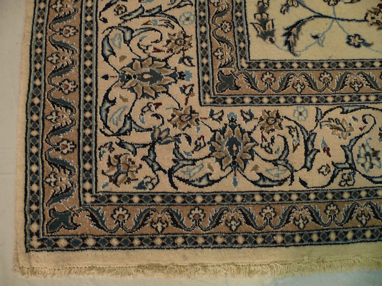 Corner view with border detail and contrast between beige field and blue-accented motifs