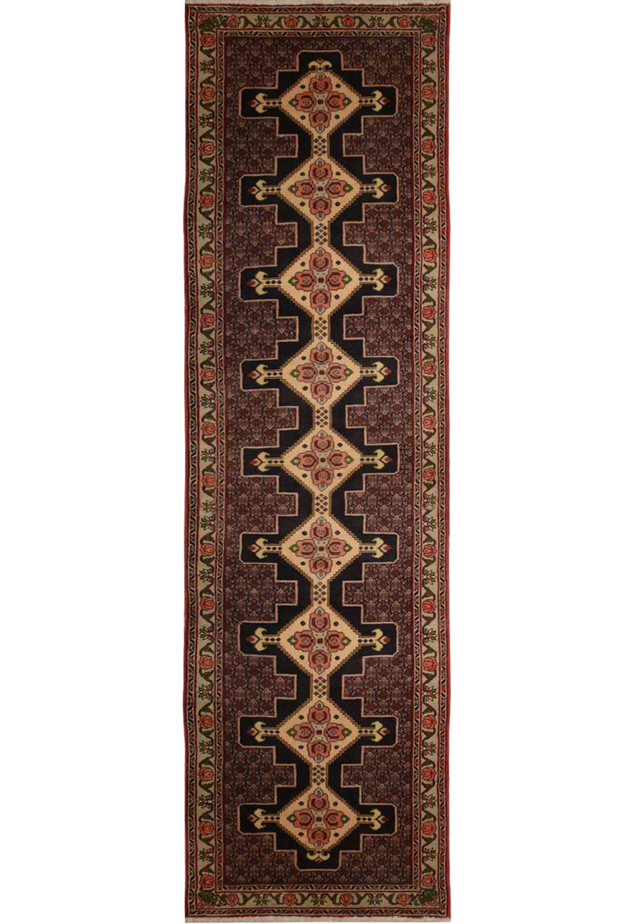 A close-up of a Persian Senneh runner featuring a geometric pattern in shades of blue, red, and ivory.