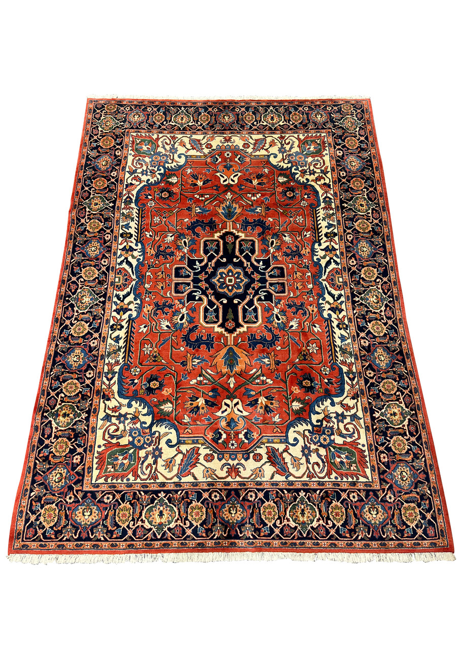 6'7 x 9'7 Geometric Persian Heriz rug laid flat showing bold red field, navy medallion, ivory accents, and classic Heriz layout