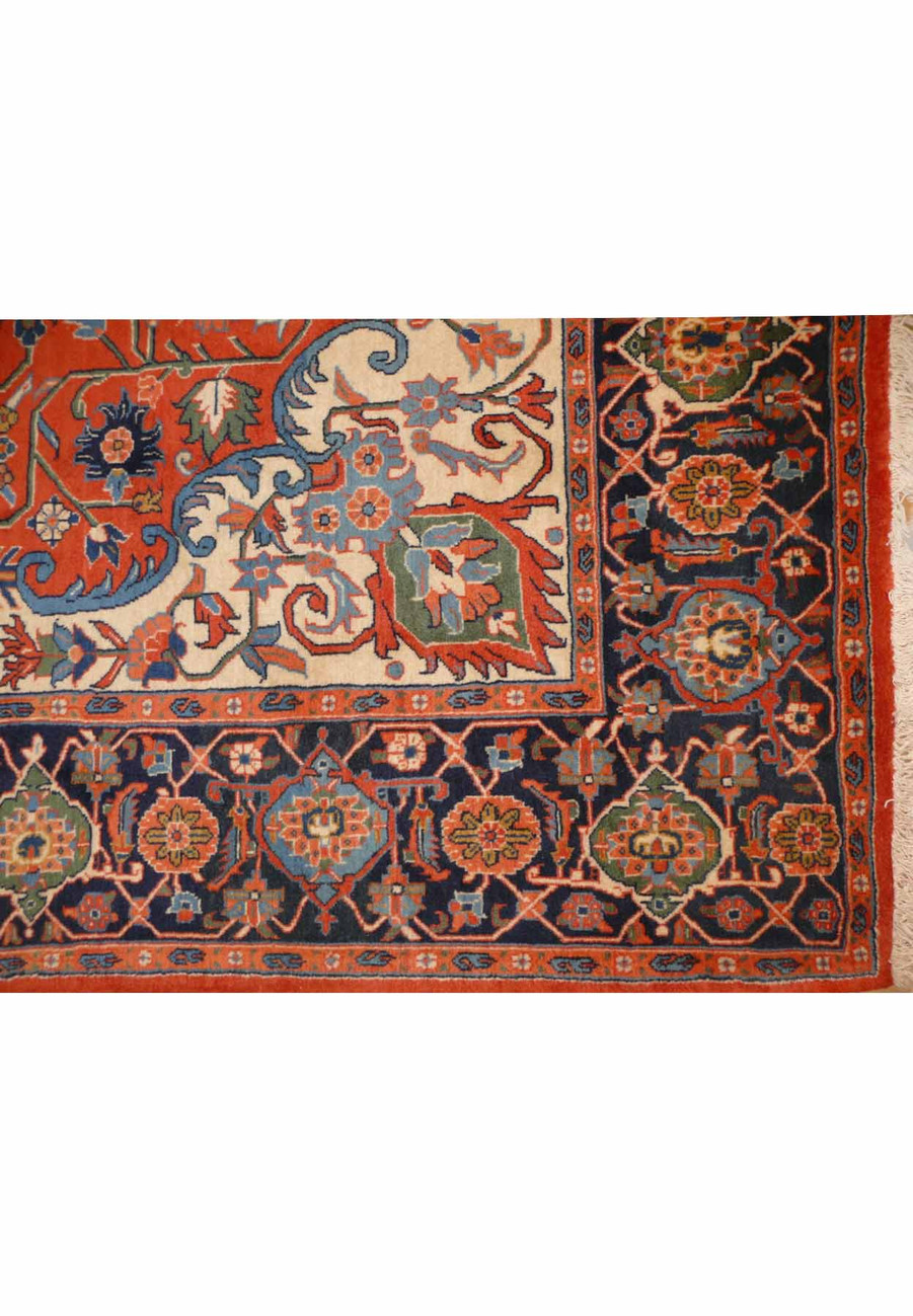 Detailed view of the geometric border on a Persian Heriz rug showing rosette motifs, angular vines, and deep navy contrast
