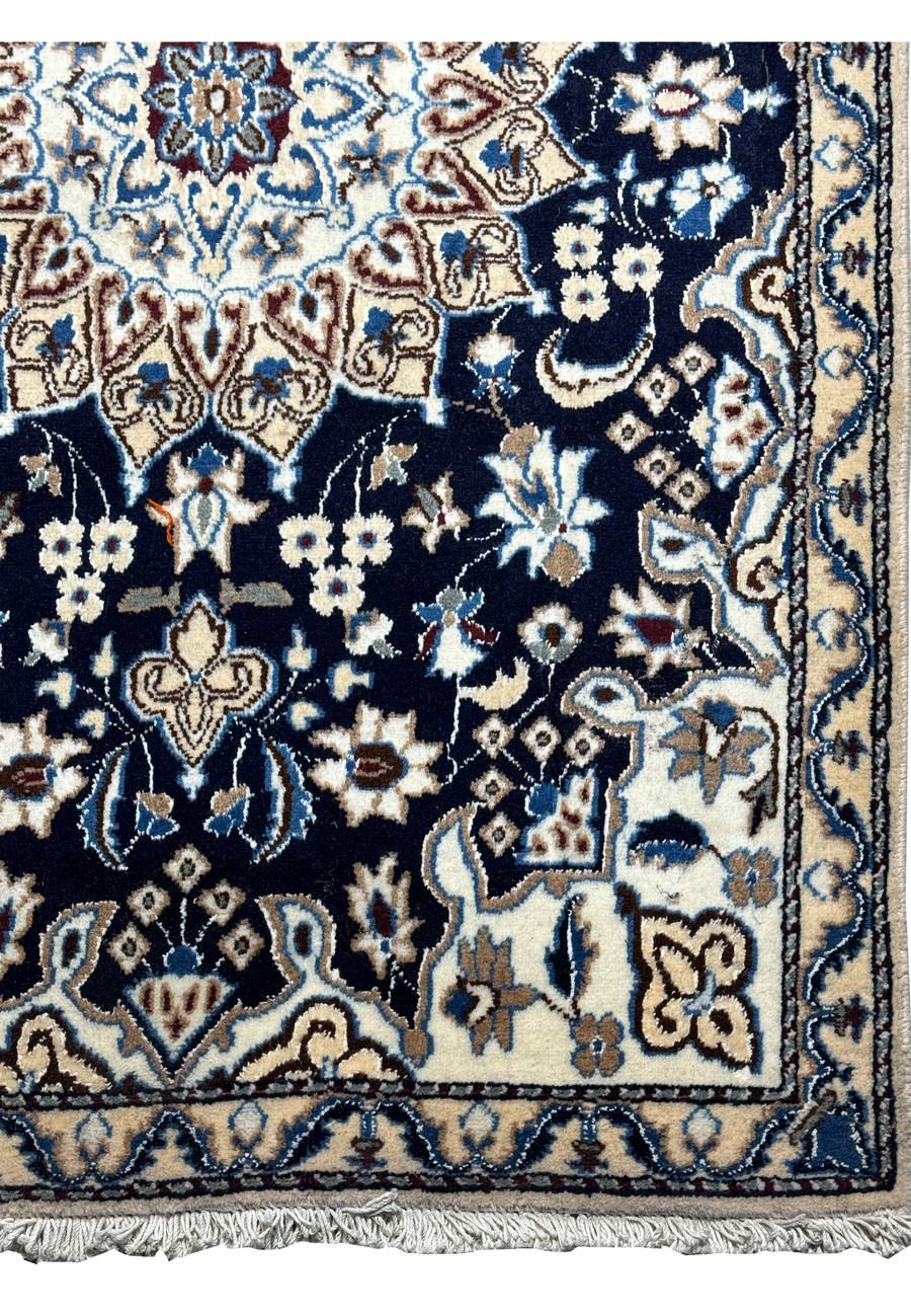 Corner detail of the Persian Nain rug with fringe, showcasing the precision of the guard bands and motifs