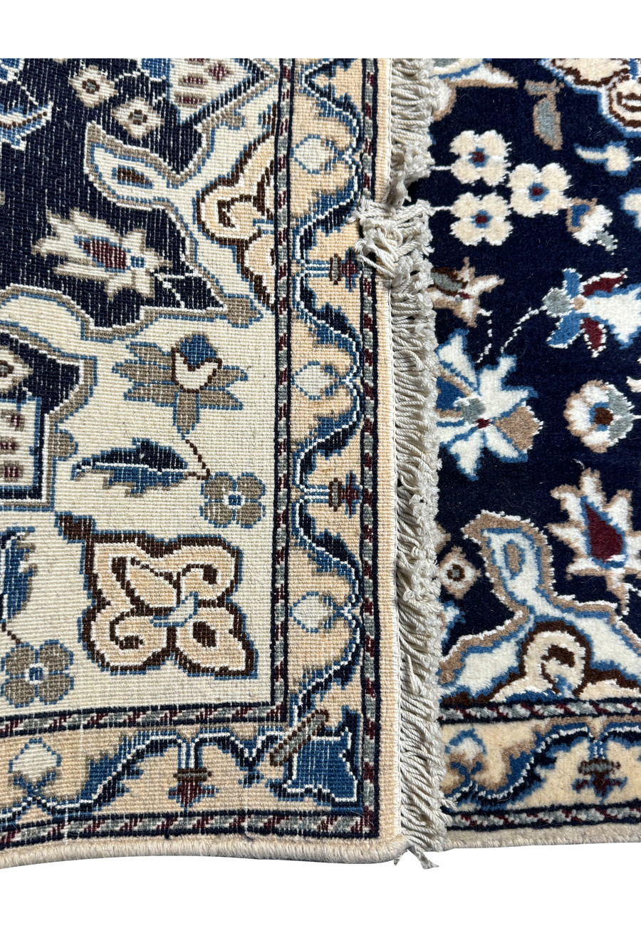 Angled perspective of the Persian Nain rug, accentuating the lush pile and elegant floral patterns