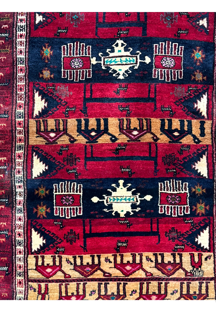 Close-up on the central pattern of a Persian Baluch Tribal rug, highlighting the intricate tribal designs and animal figures