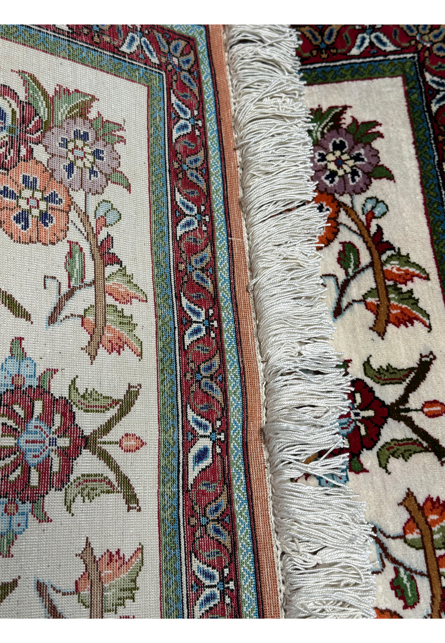 Macro shot of the Persian Qum silk rug's pile, showcasing the precision of the silk knots and the vibrant color scheme