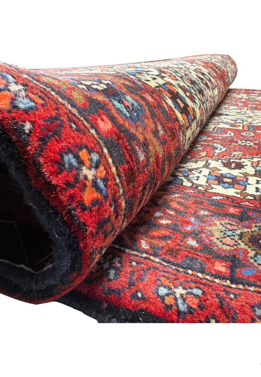 Rolled 3x5 Persian Gholtogh rug showing the texture and thickness of the woolen weave.