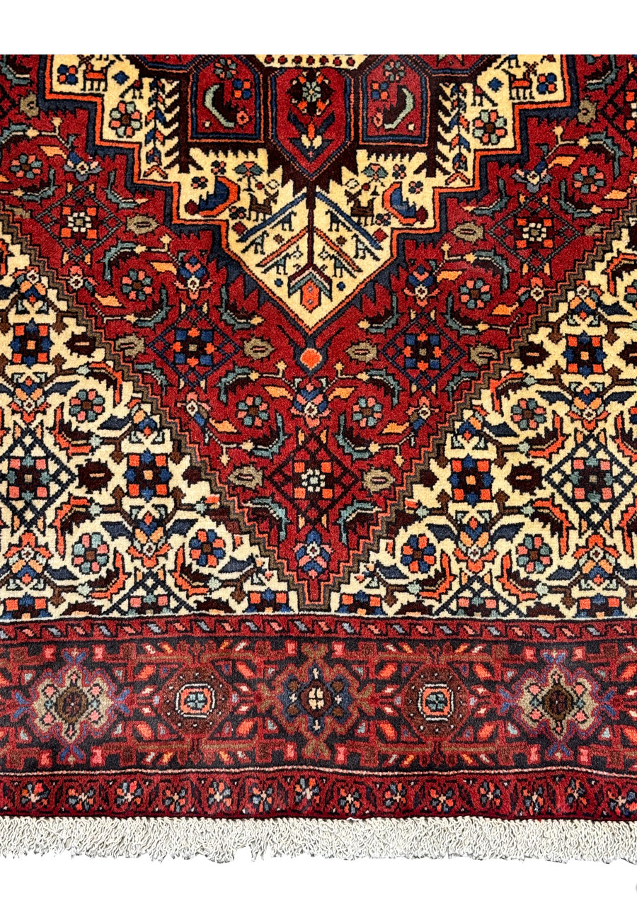 Close-up of the Persian Gholtogh rug's detailed geometric motifs and deep red background