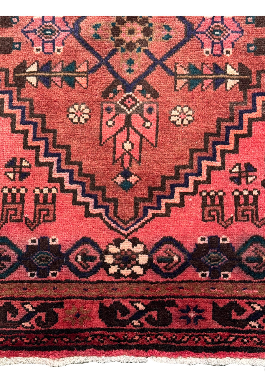 Detailed imagery showing the deep navy blue and charcoal accents on the Persian Baluch rug