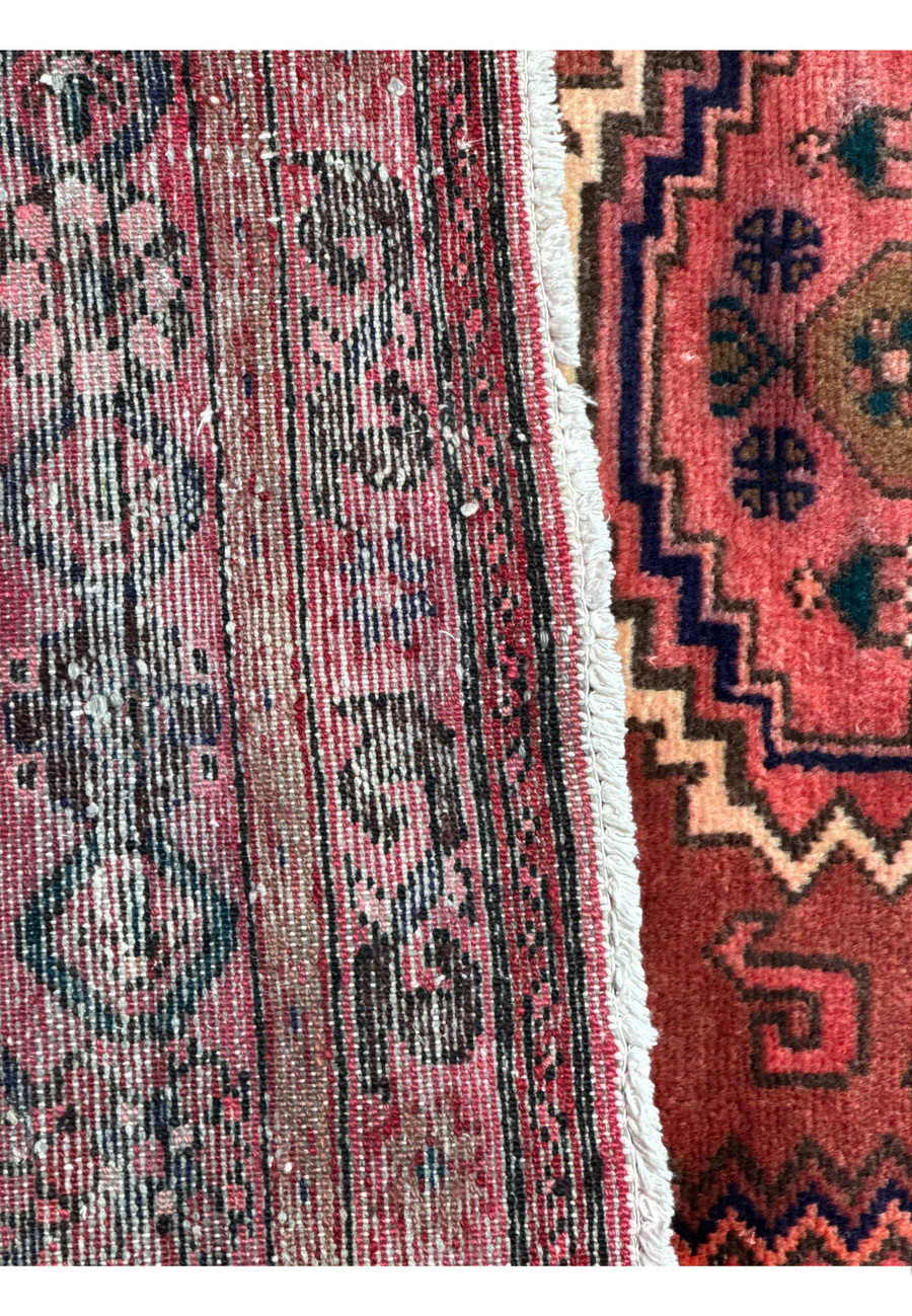 Texture-focused close-up of the Persian Baluch rug, illustrating the high-quality weave and color depth