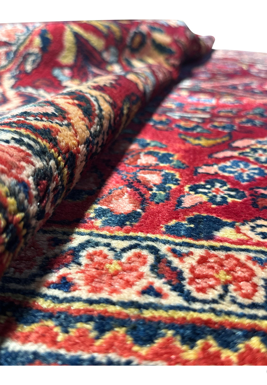 Side view of a rolled 4x7 Antique Persian Lilihan Rug, emphasizing the texture and thickness of the weave.