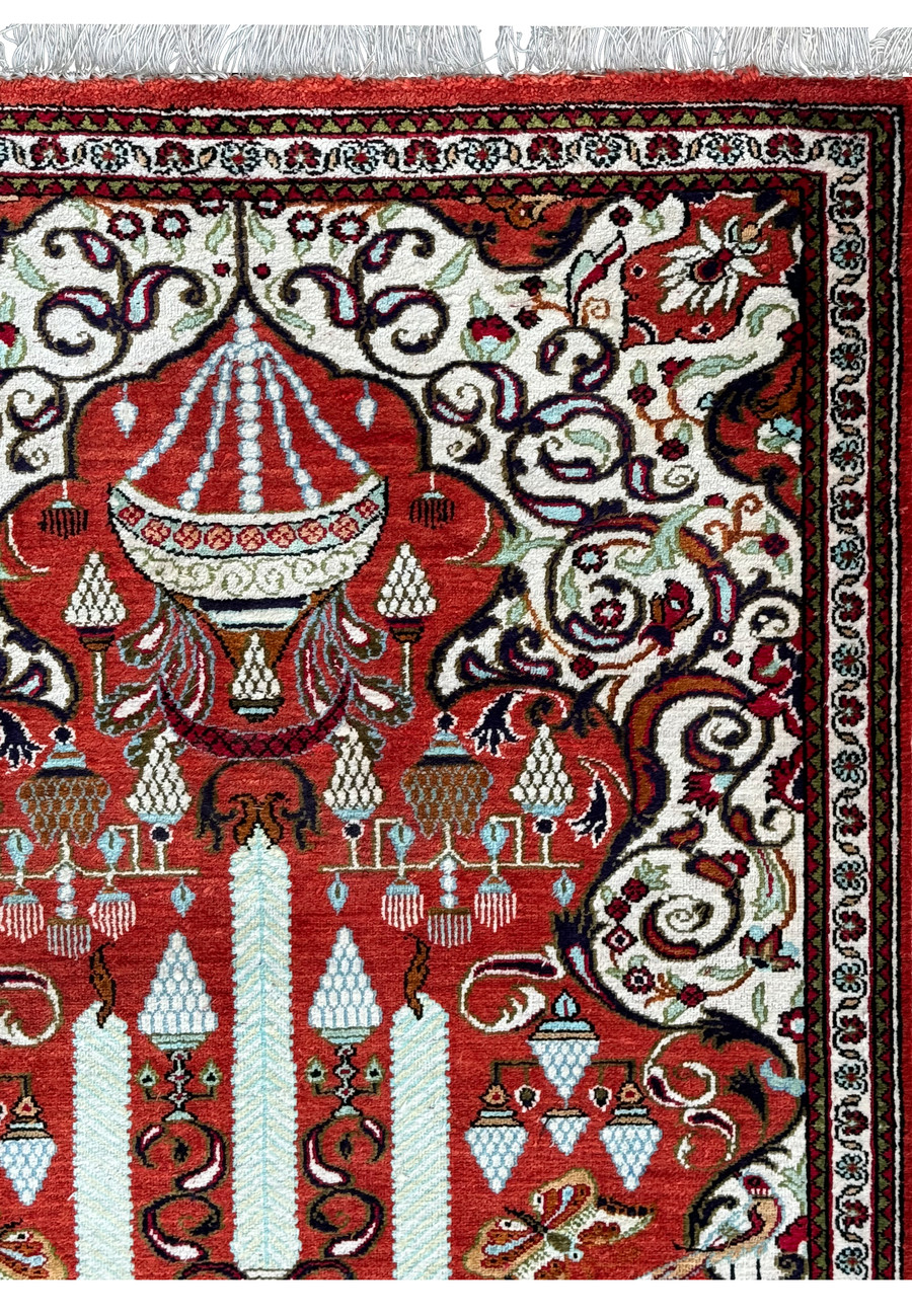 Detailed view of the central chandelier motif on a Persian Qum silk rug, symbolizing enlightenment