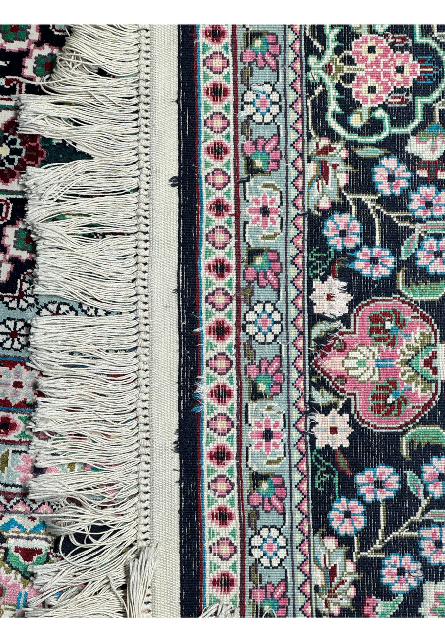 Detail of the fringe and weave structure of a Persian Qum silk rug, displaying exceptional artisanship