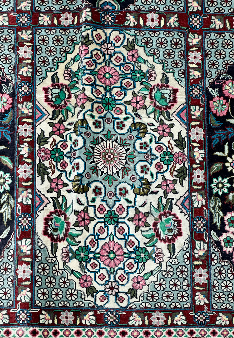 Perspective shot of a Persian Qum silk rug, highlighting the depth of design and vibrant colors