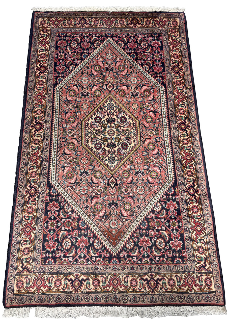 Angled view showcasing the dense weave and rich color variations of the Persian Bijar rug with detailed borders and fringe