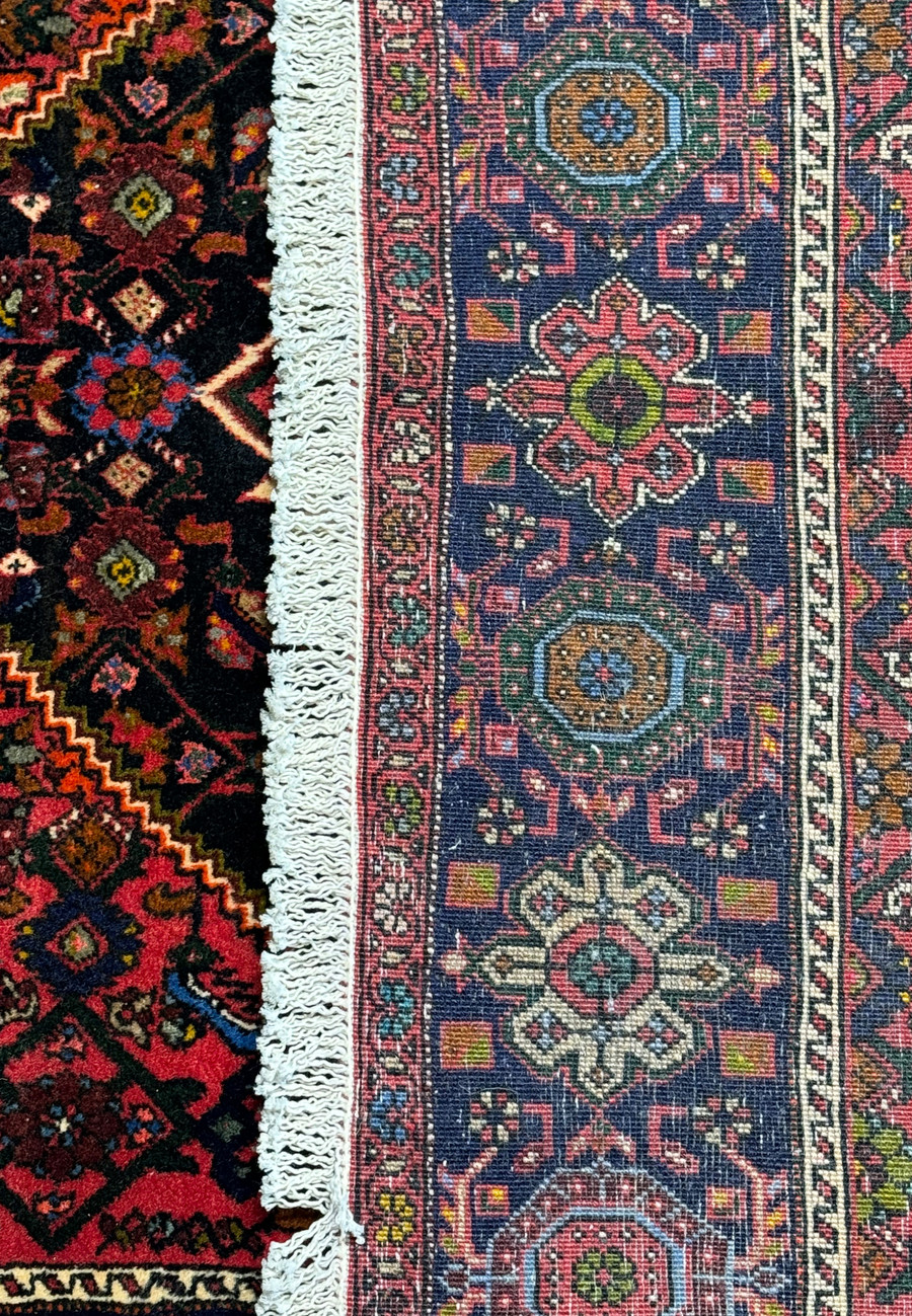 Perspective view of the Persian Gholtogh rug showing the plush texture and the detailed edge finishing with fringes.