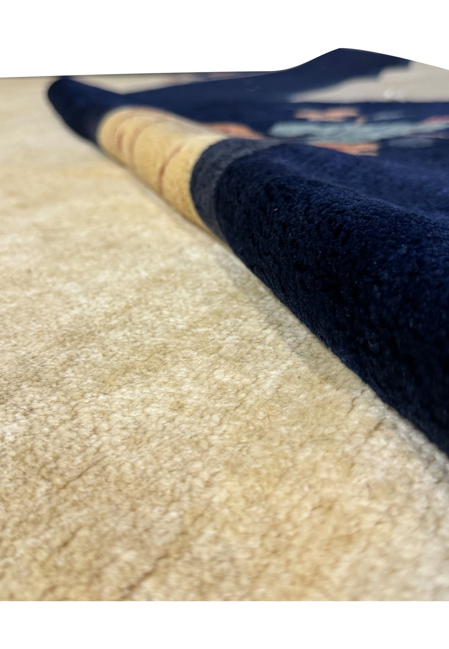 Diagonal view of the vintage Art Deco rug's navy blue border meeting the beige center, adorned with floral patterns