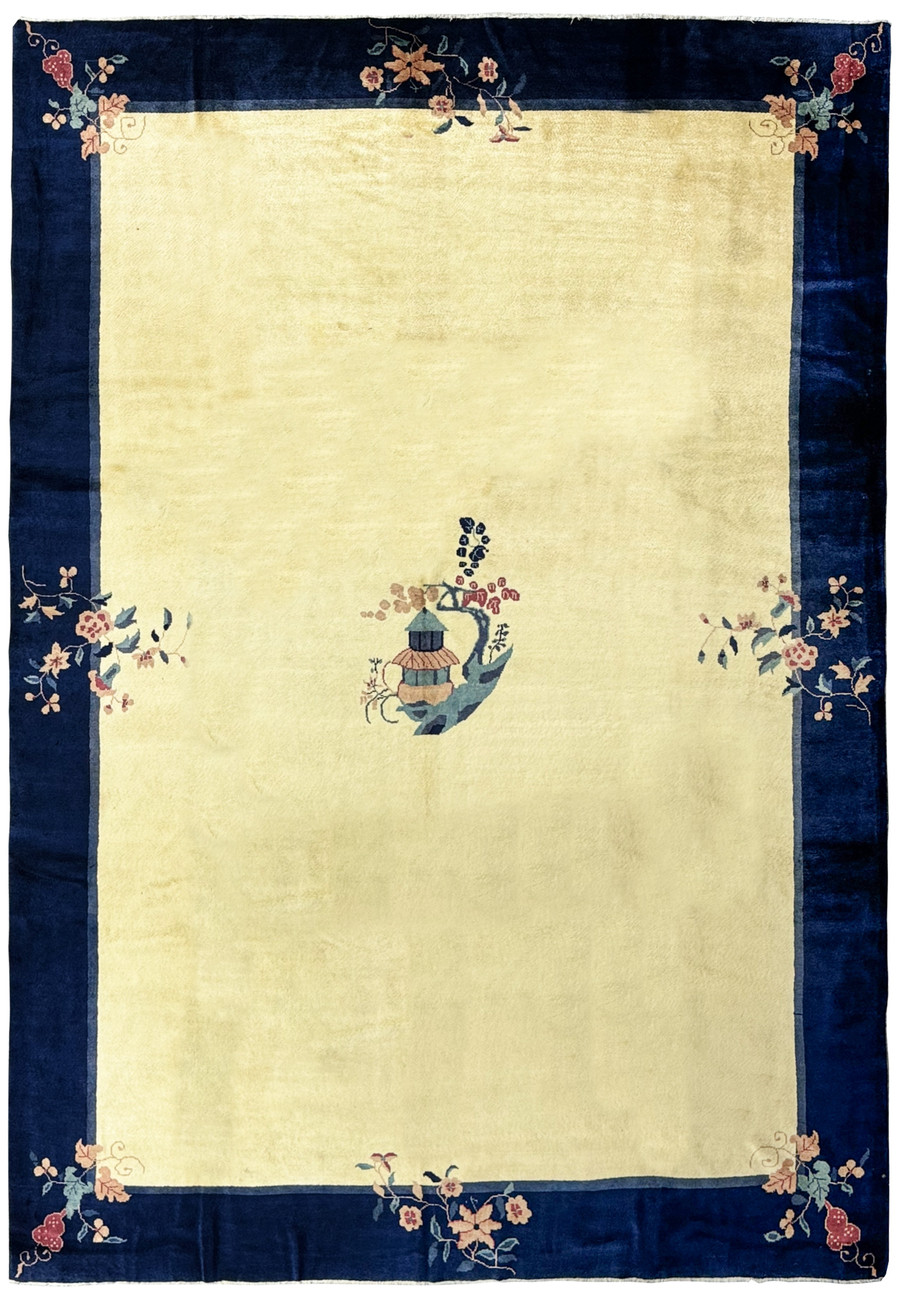 A 10 x 14 vintage Art Deco rug with a navy blue border and a central beige field displaying a stylized vase motif and corner floral designs, in pristine condition