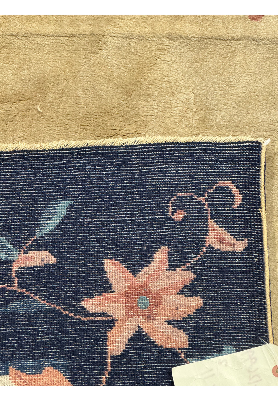 Zoomed-in view of a 1960s Vintage Art Deco Rug corner, illustrating the fine details and weaving technique of the floral design against the navy border back of the rug