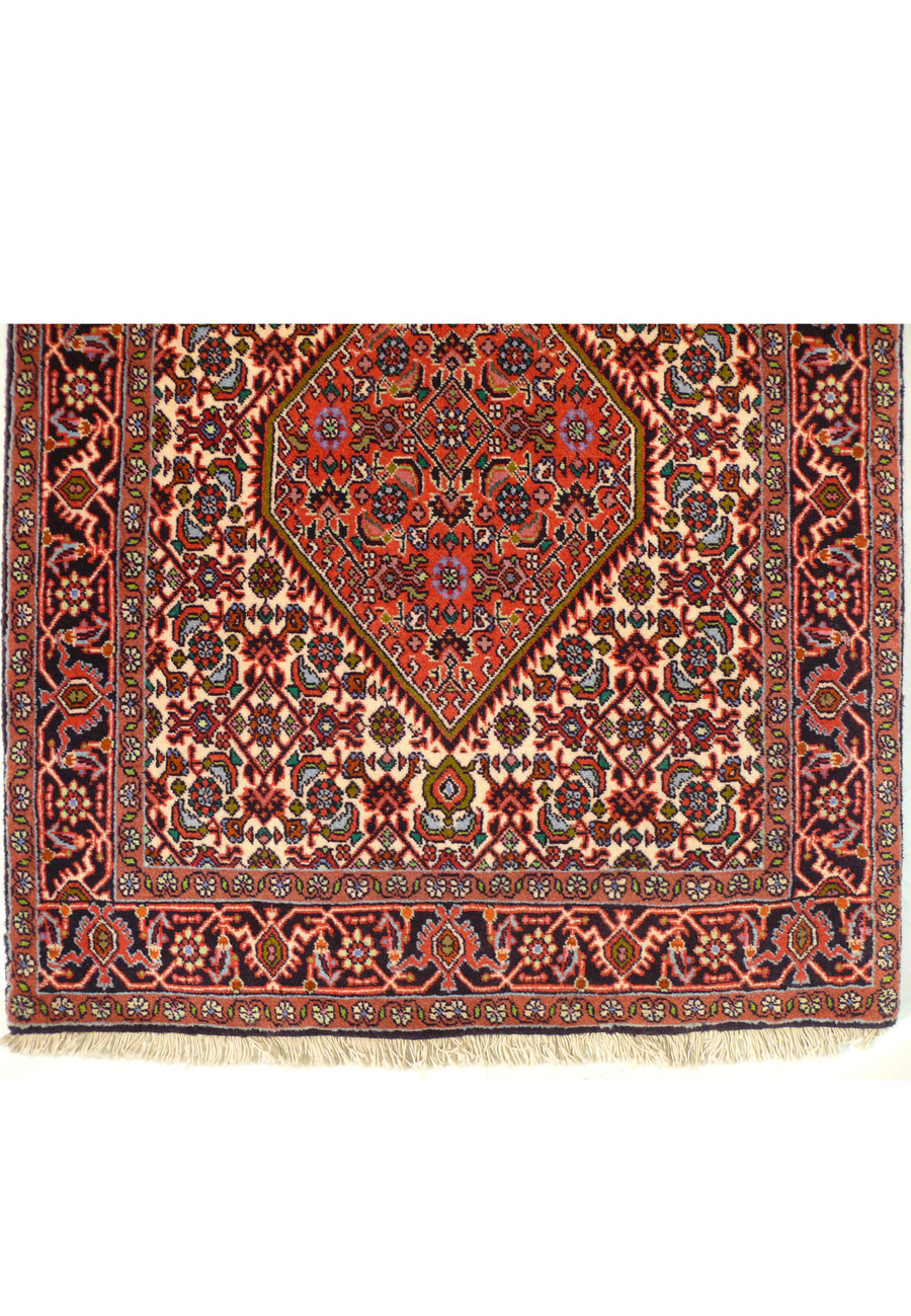 Detailed close-up of the central design of a Persian Bijar Runner Rug, featuring symmetric medallions and a complex interplay of colors