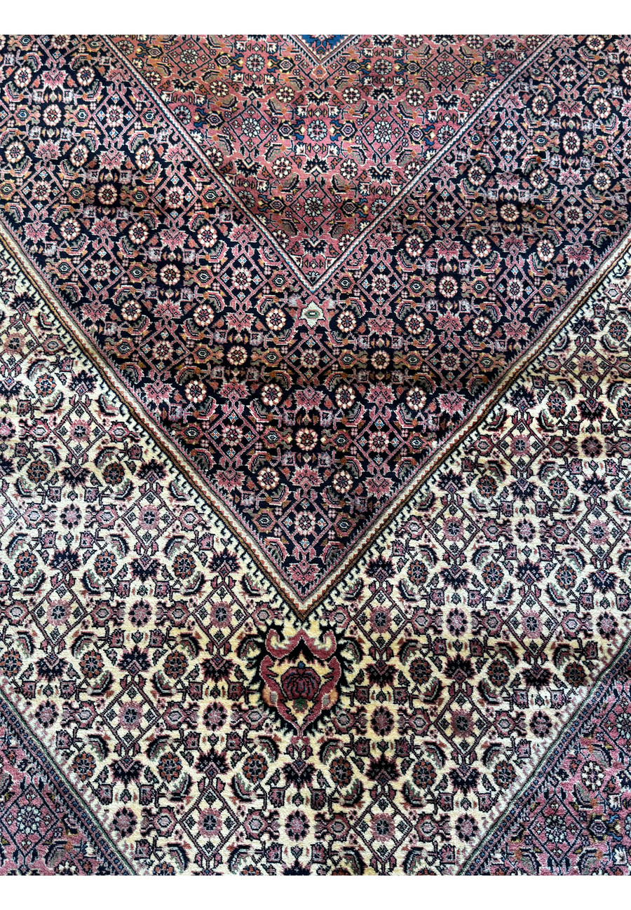 The central medallion on this 12x17 Bijar Persian rug is a masterpiece of design, featuring an ornate composition of intricate motifs and symbols that epitomize the artistry of Persian rug-making