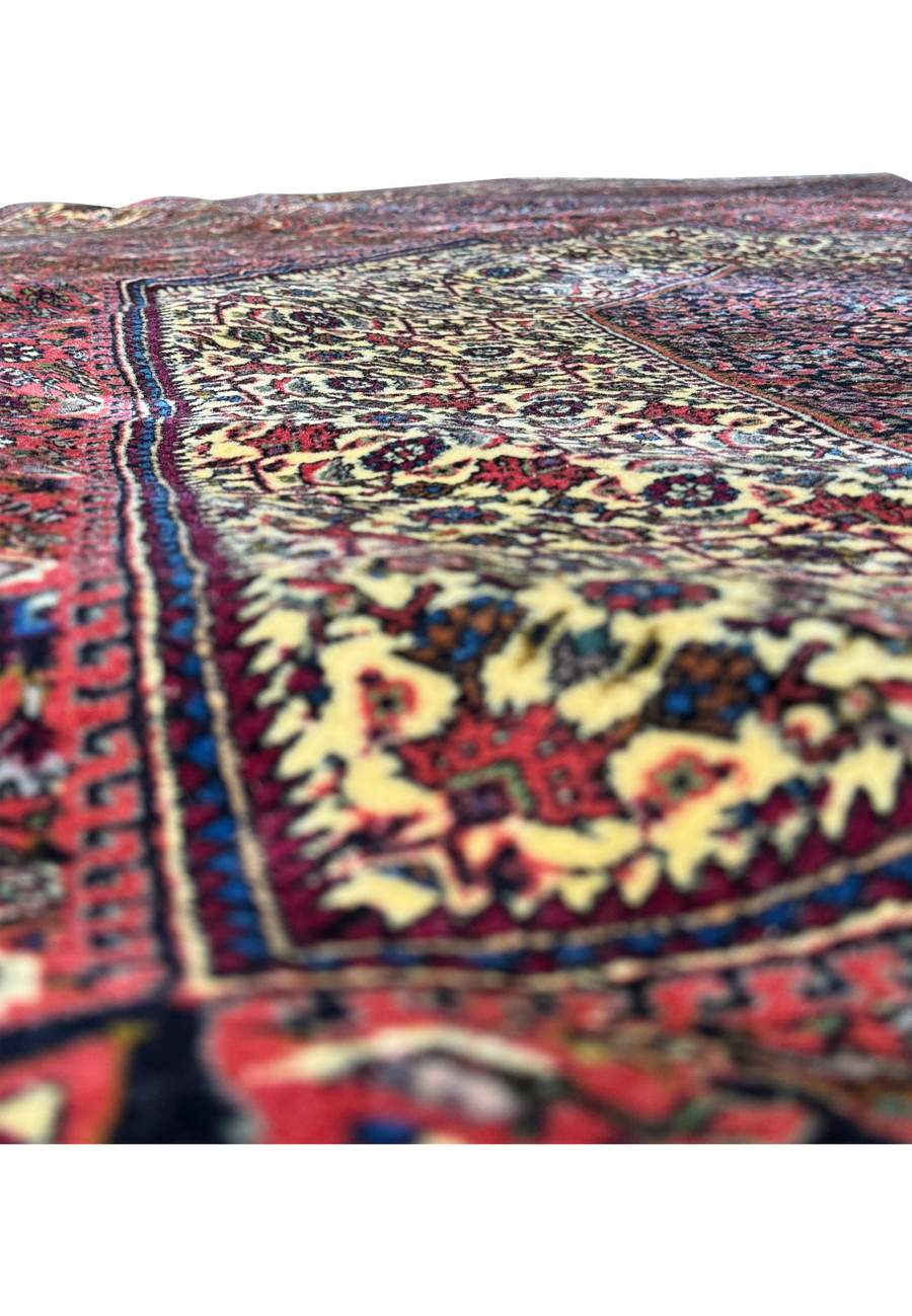 Another angle of the rolled Persian Bijar rug, emphasizing the tightness of the roll, the layering of patterns, and the play of colors that creates a three-dimensional effect in the textile