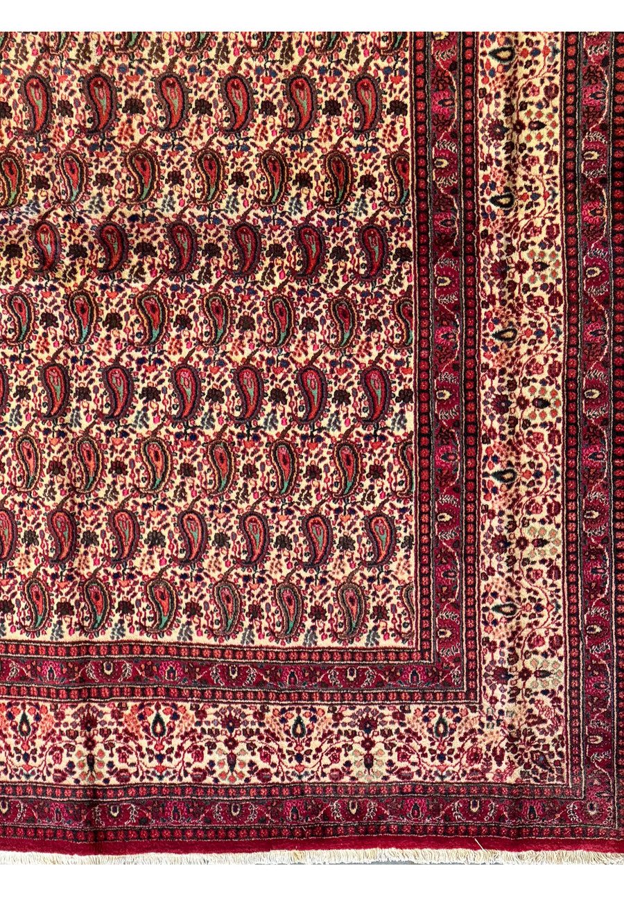 Detailed perspective of the Persian Moud Rug's surface, illustrating the fine craftsmanship and rich texture of the woven wool with a deep red and blue color scheme