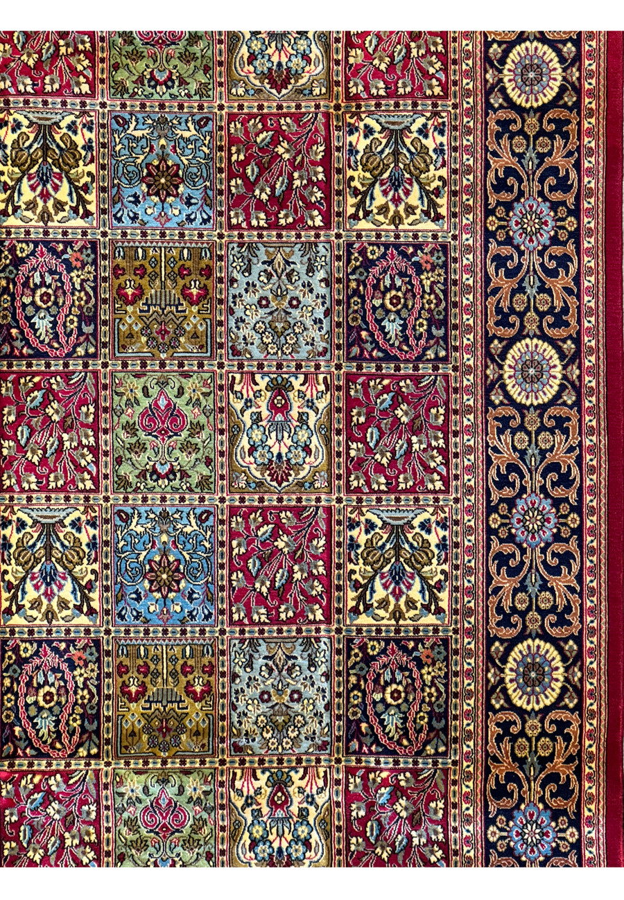Magnified view of a Persian Qum Kork rug's corner, revealing the detail in its border and the precision of its panel squares with floral motifs