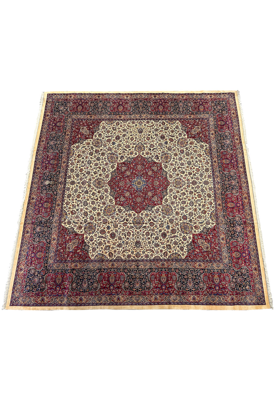Angled perspective of a large, never-used 20x20 square Persian Mashad rug, highlighting the detailed central medallion and surrounding intricate patterns, with vibrant colors including deep red, blue, and ivory, set within a beautifully patterned border.