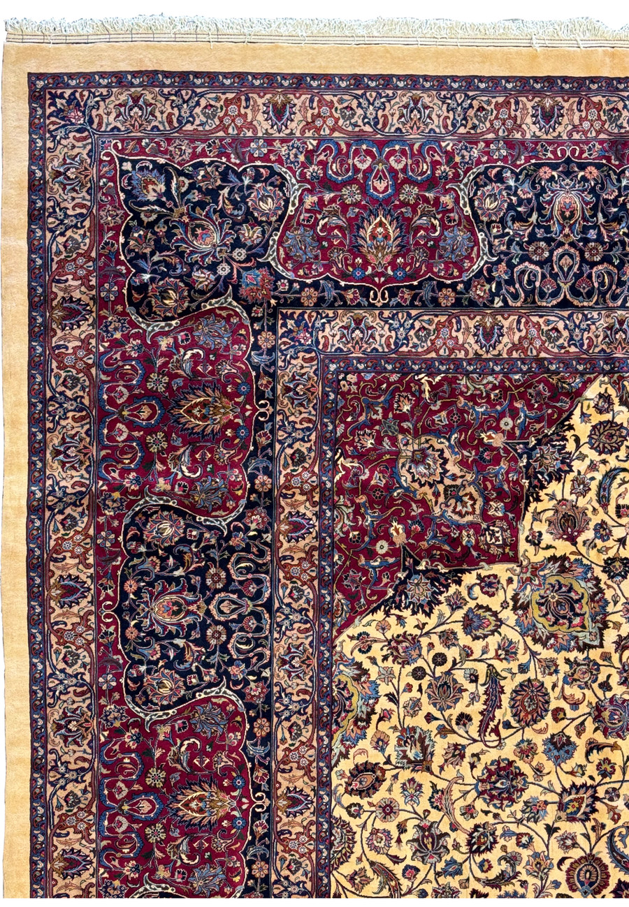 Close-up of the elaborate border of a Persian Mashad rug, featuring interconnected floral and vine motifs in deep red, blue, and beige, framing the central field with precision and elegance.