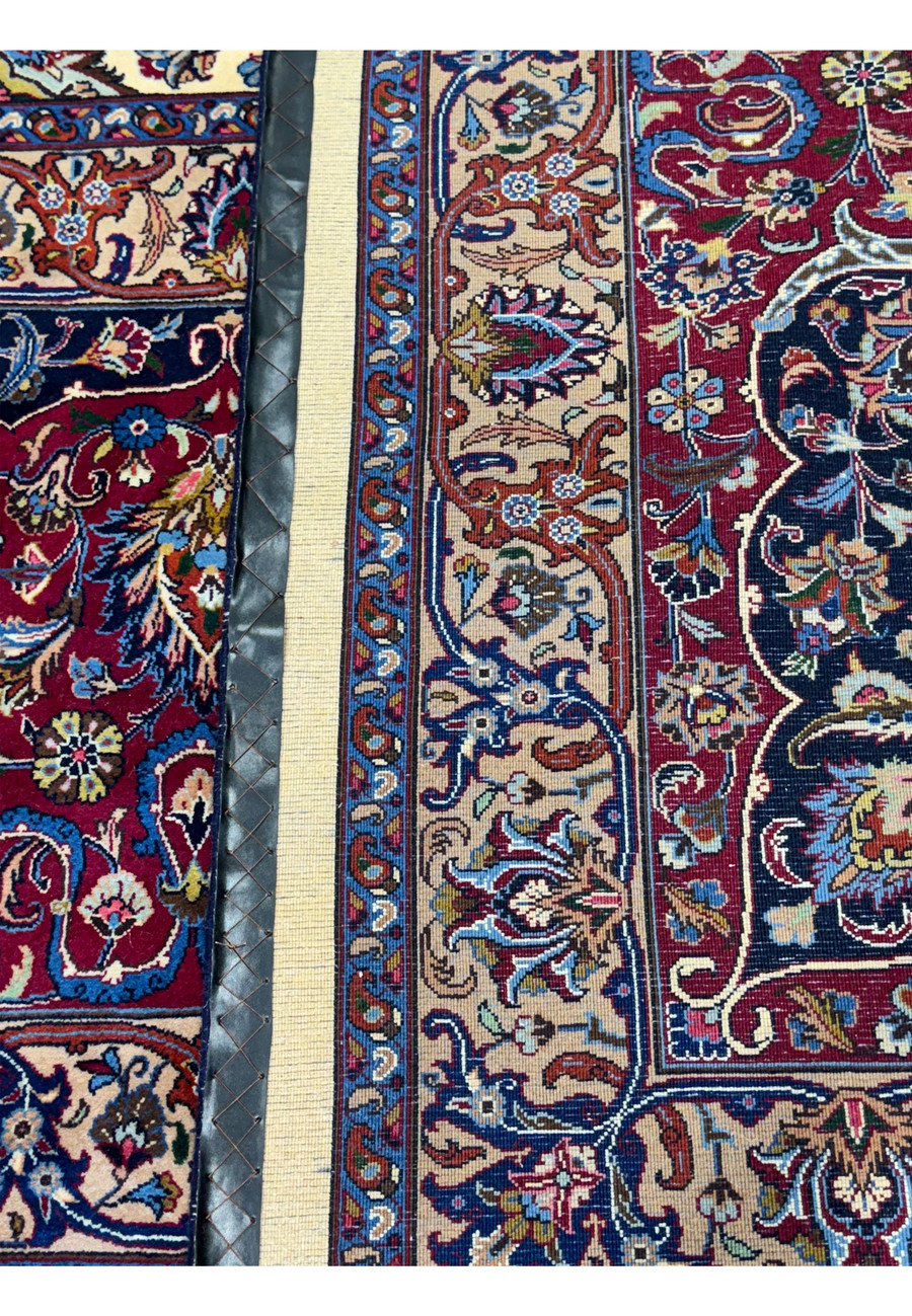 Detailed view of the backside of a Persian Mashad rug, illustrating the high knot density and quality craftsmanship, with clear visibility of intricate patterns and vibrant colors such as red, blue, and beige, demonstrating the rug's superior construction and durability.