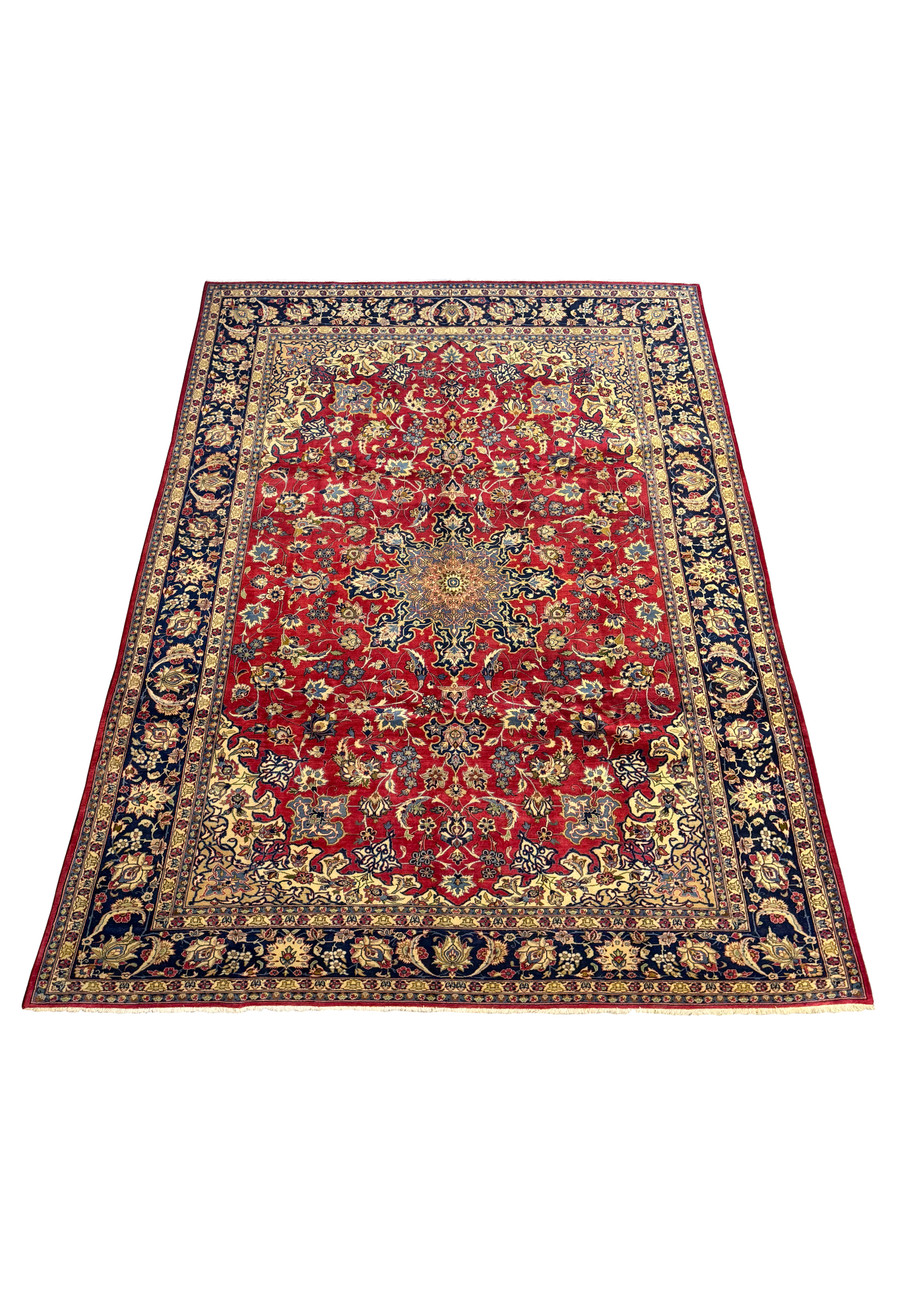 Angled view of a large 10 x 14 Isfahan Persian rug showcasing its rich red color and elaborate border design