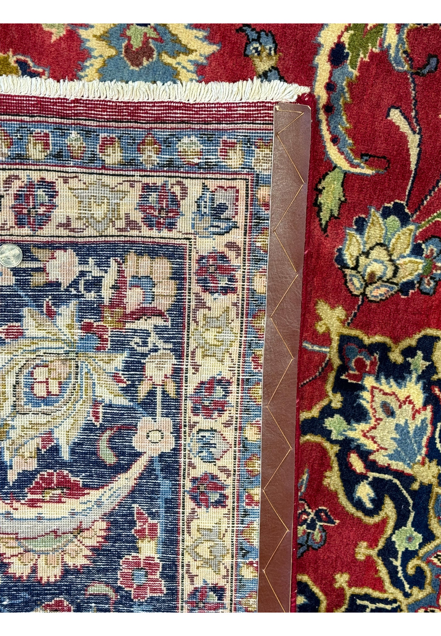 Zoomed-in view of the backside of a Persian Isfahan rug, with a coin placed for size reference, showing the intricate knots and the high-quality wool used in the weaving process