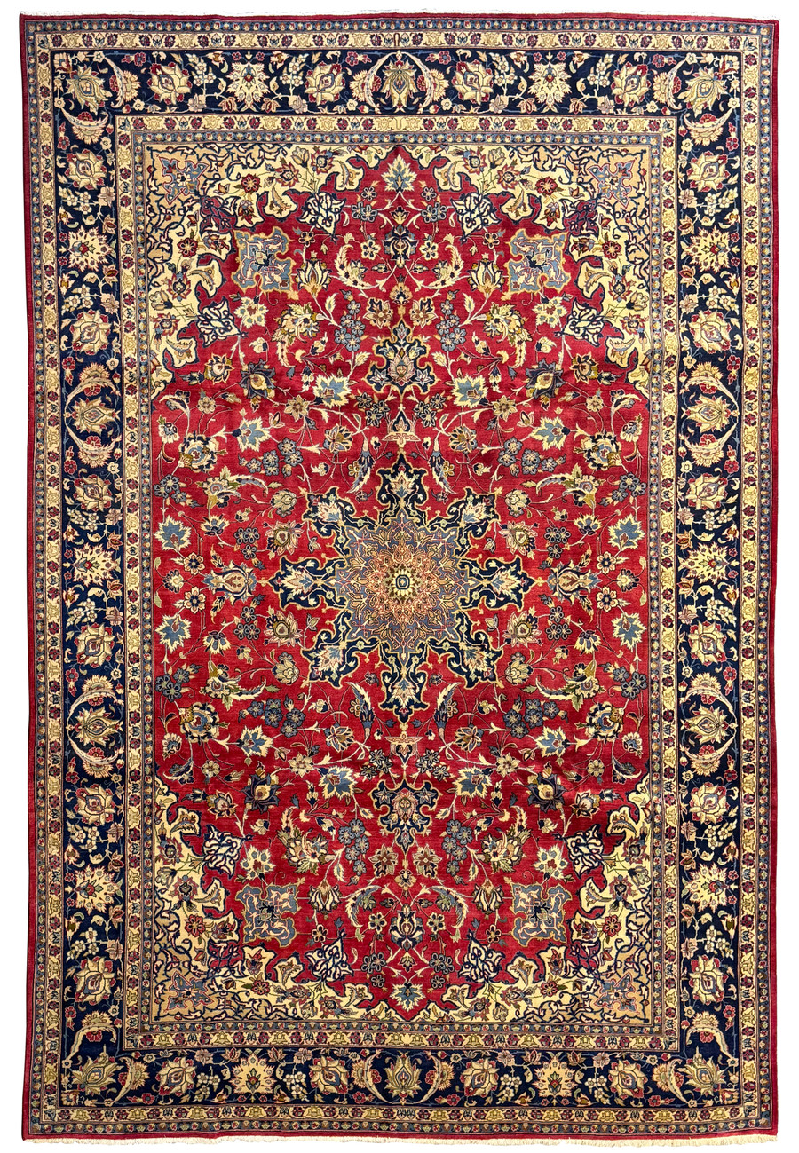 Top view of a 10x14 Persian Isfahan rug with a red field, intricate floral motifs, and a detailed central medallion