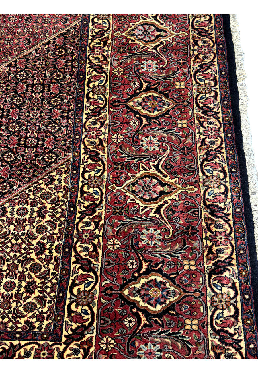 Close-up view of the intricate floral border design on the Persian Bijar Rug, showcasing the rich red and gold colors.