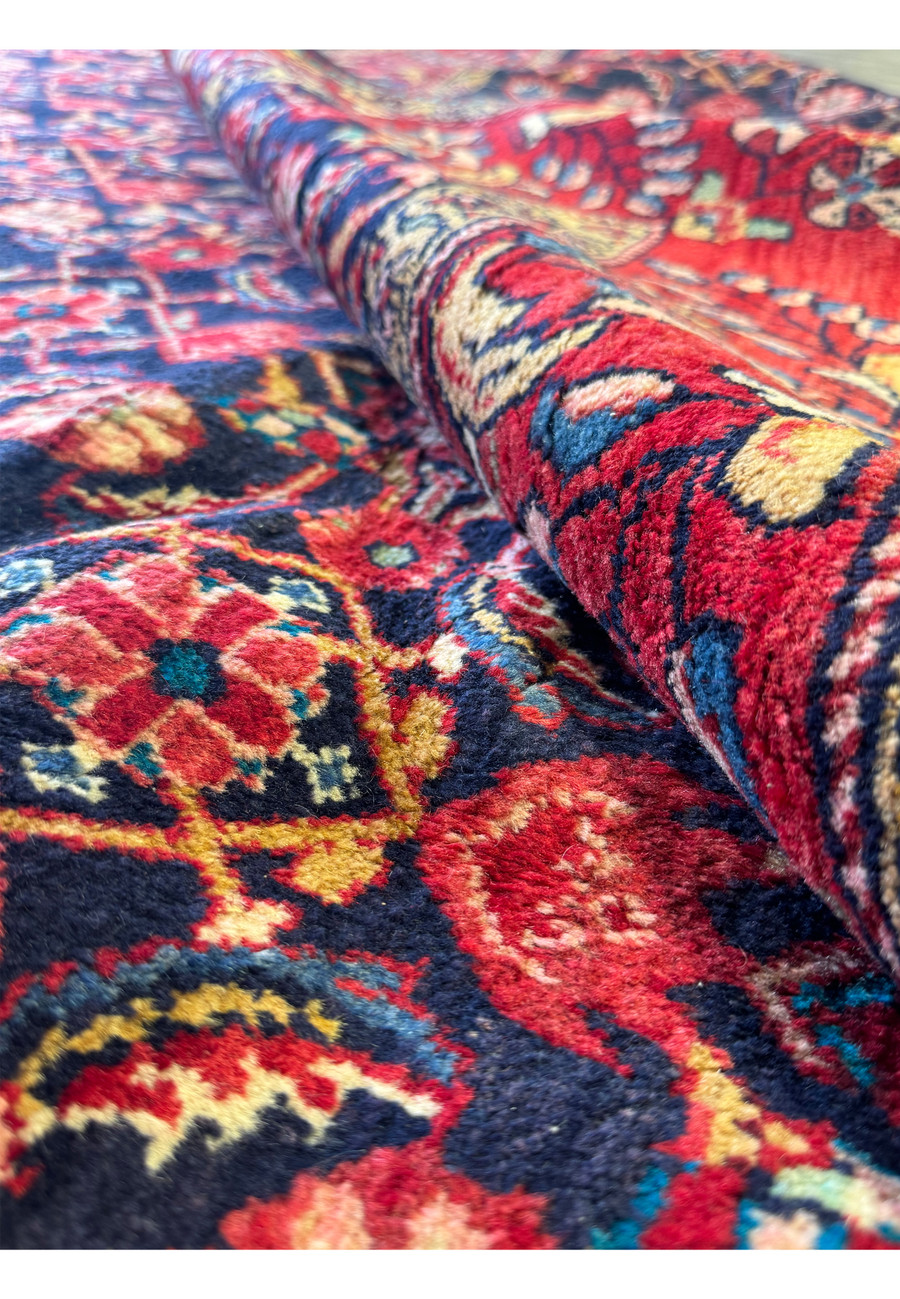 Rolled edge of a Persian Mahal rug, displaying the plush wool pile and intricate design.