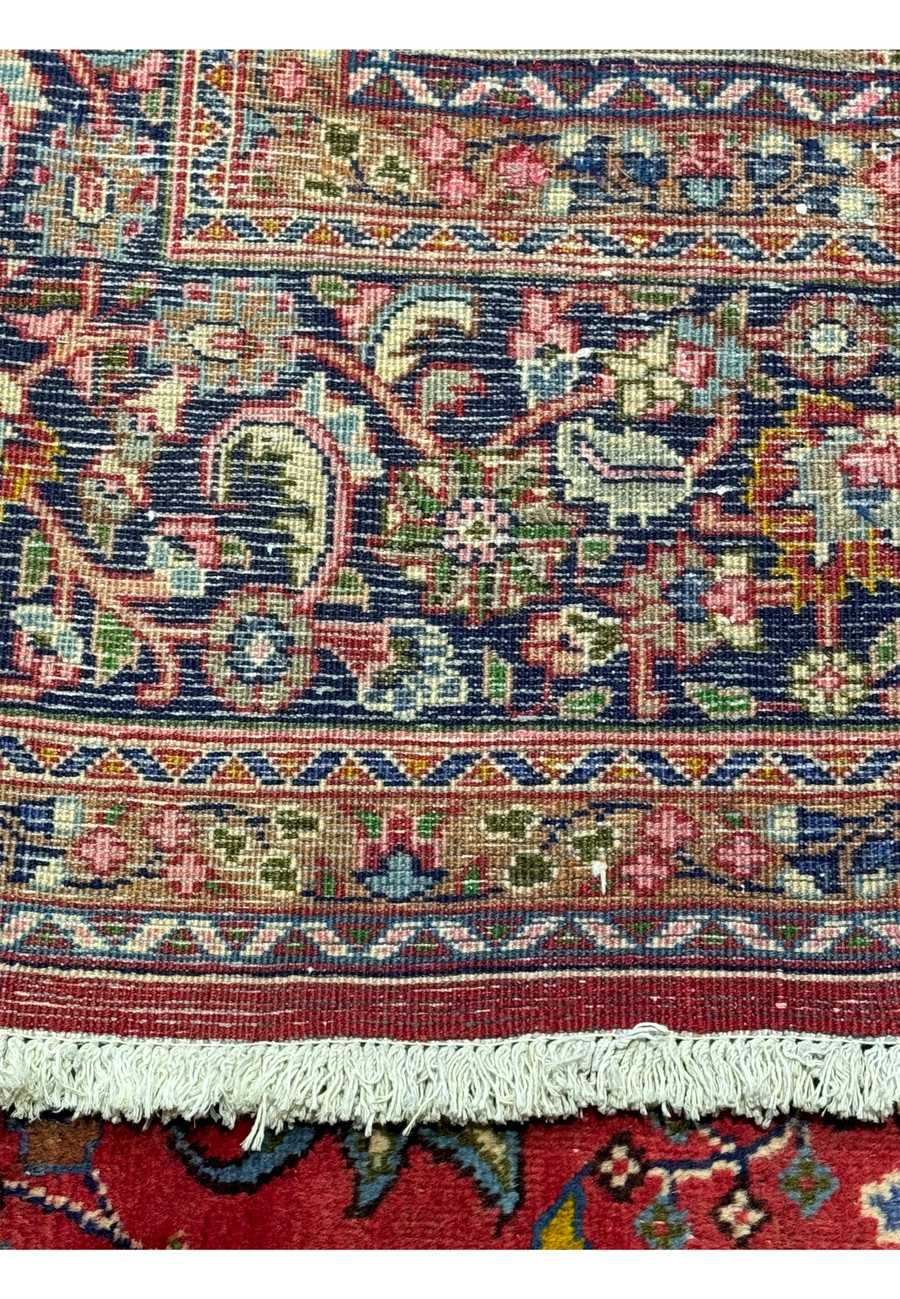 Perspective shot of the Mashad Persian  rug, showing its luxurious texture and intricate design highlighting the back of the rug