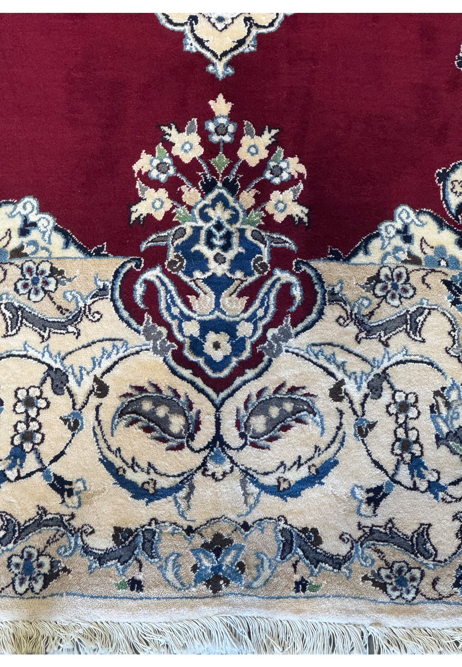 Detailed look at the lower edge of the 6'8 x 10'4 Persian Nain 9LAA Wool & Silk Rug, showing the fringe and border motifs.