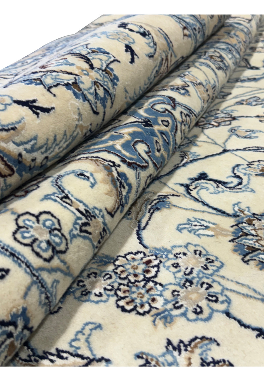 Rolled view of a Persian Nain 9LA Wool & Silk Rug highlighting floral designs