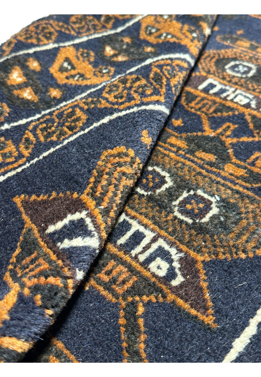 Rolled texture of the 2'9 x 4'4 Persian Baluch Rug highlighting the weave and detailed tank patterns.