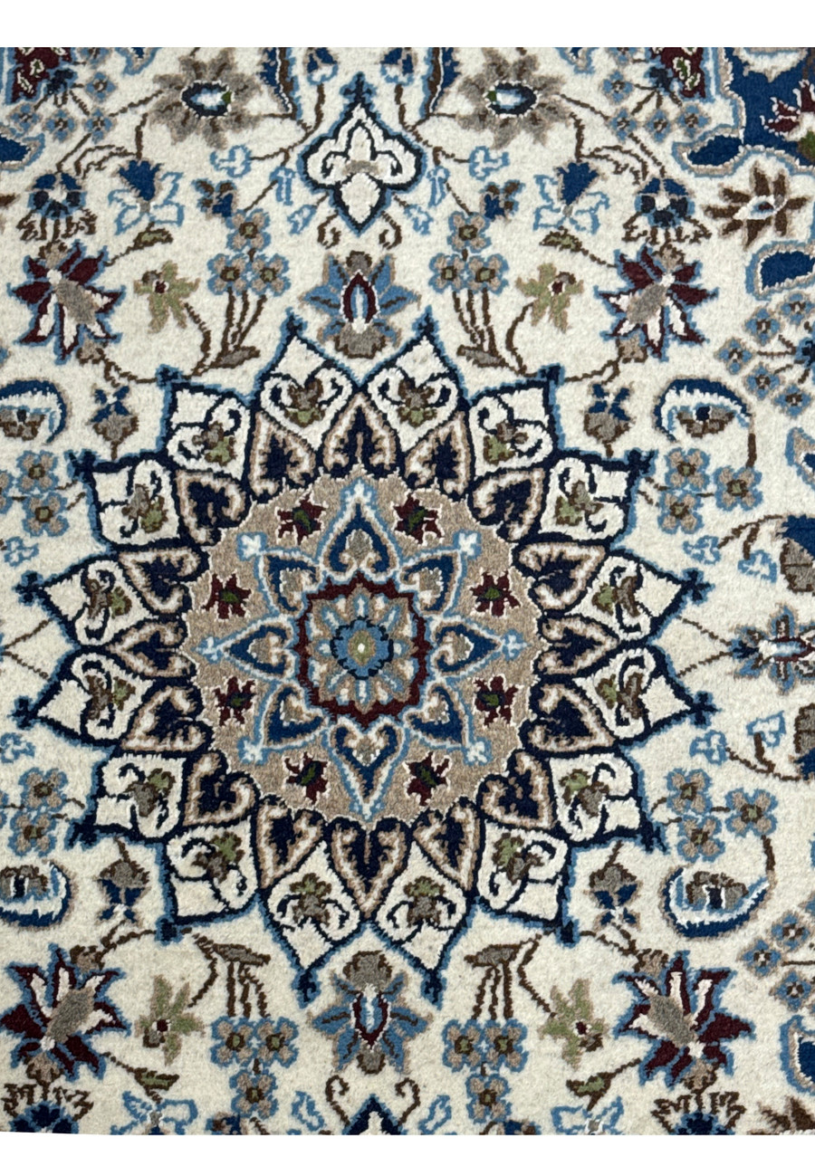 Close-up of the central medallion on a 3 x 4'6 Nain Persian Rug, featuring blue and brown accents on a cream base.