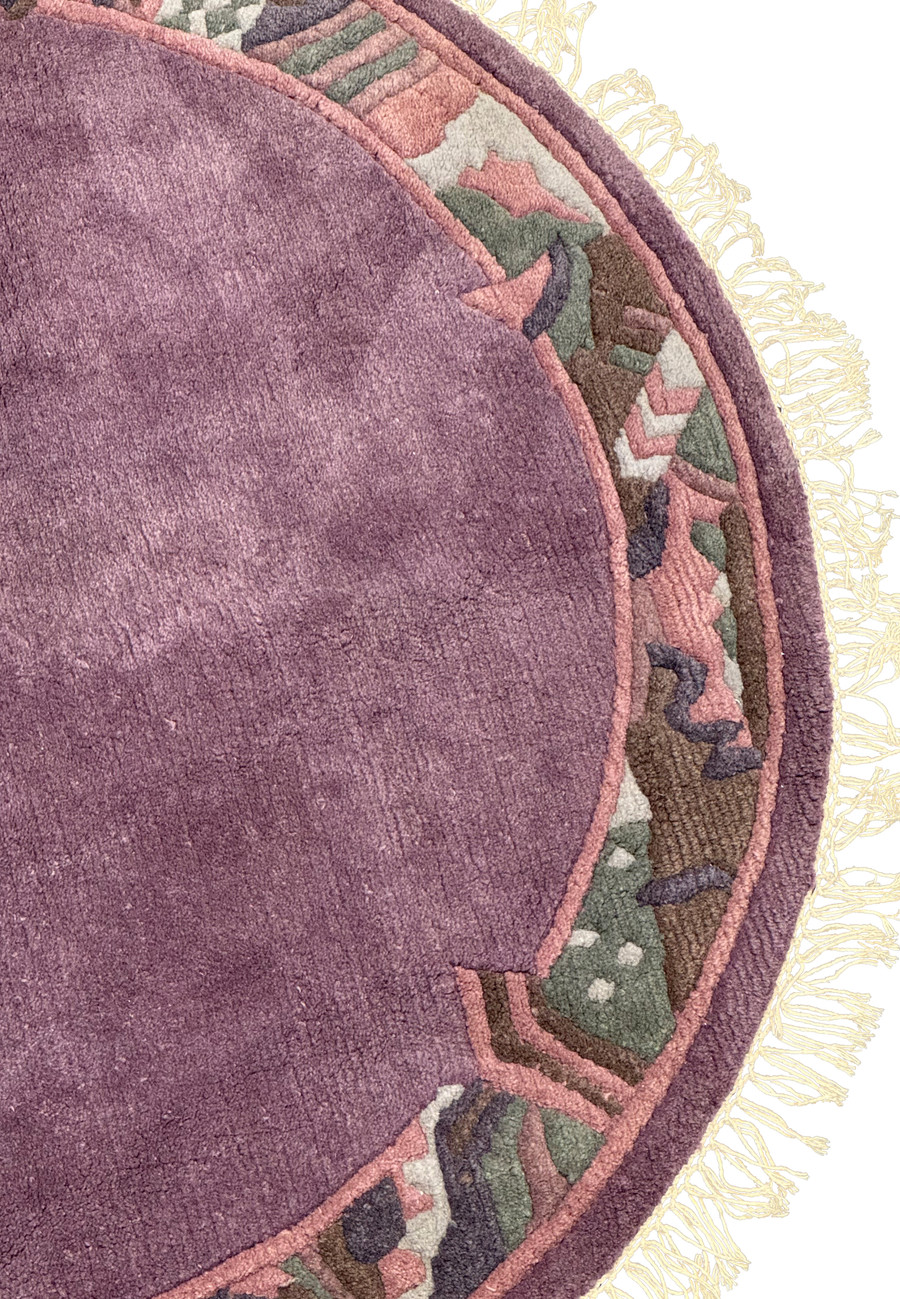 Close-up of the intricate border patterns in muted rose, olive green, and deep brown on the 4'8 x 4'8 round rug.