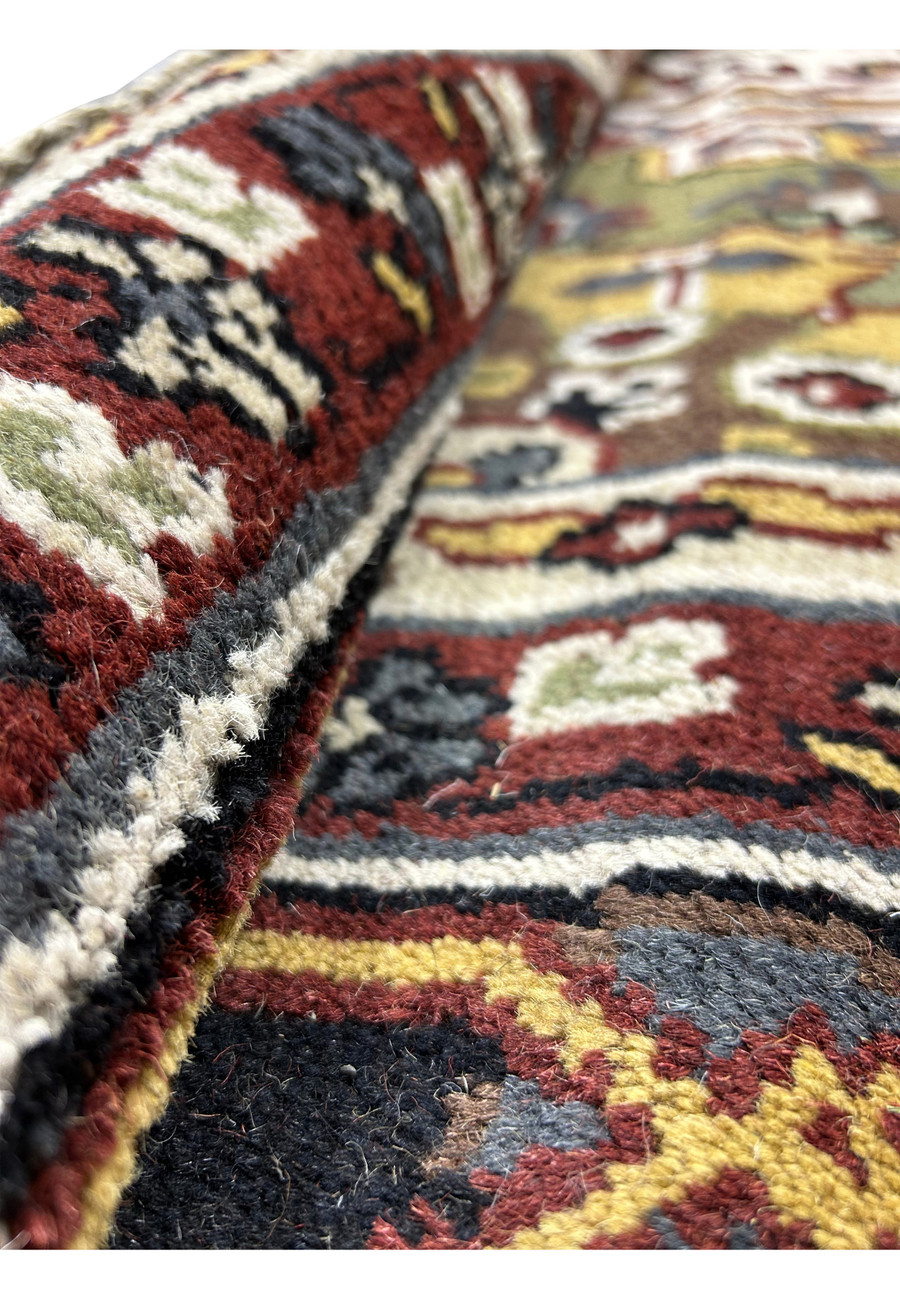 12 x 16 Oriental Heriz Rug partially rolled to show the texture and thickness of the wool.