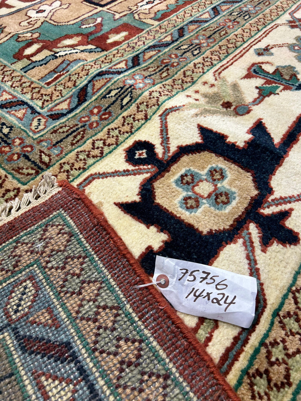 Backside of the 14 x 24 Beige Red Oriental Serapi Rug showing craftsmanship and label.