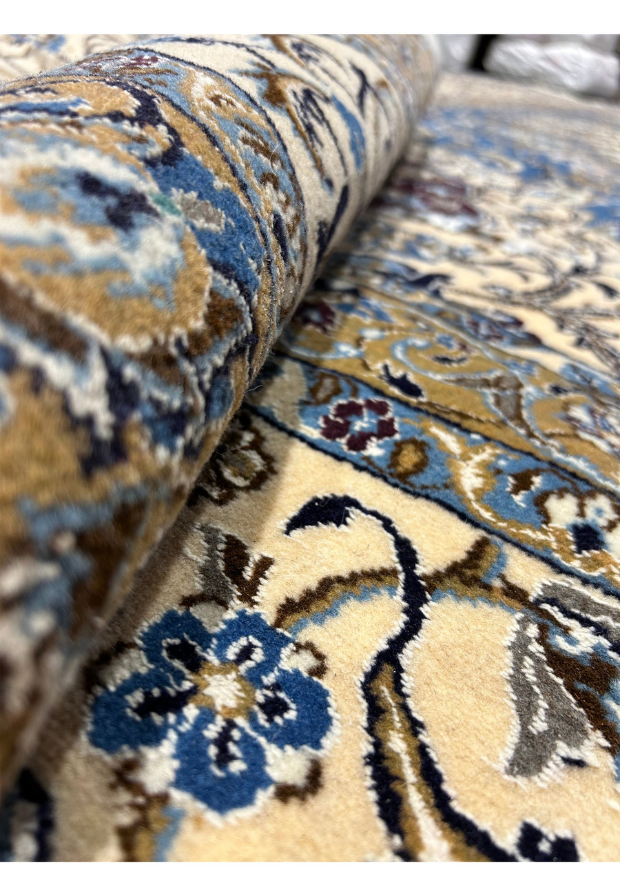 Rolled 16' x 16' Persian Nain rug showing thickness and high-quality wool pile.
