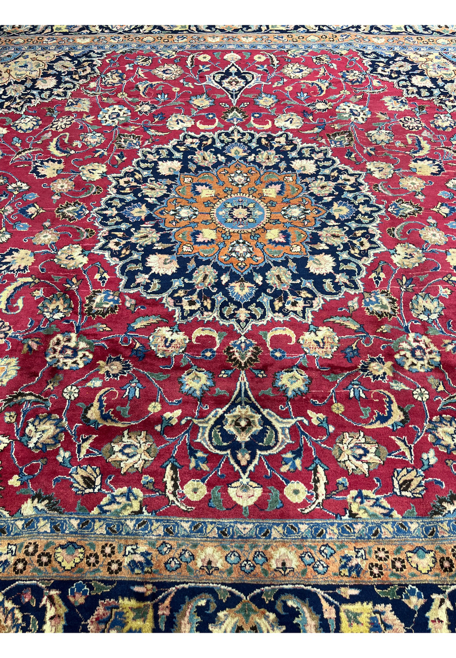 Midfield section of Mashad Rug with dense floral patterns on red background